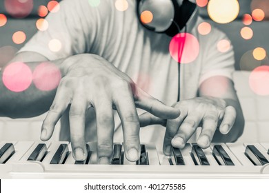 musician hands playing piano with colourful bokeh