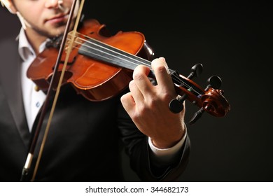 Musiker spielen Geige auf schwarzem Hintergrund, Nahaufnahme