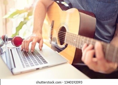 Musician Playing Acoustic Guitar And Recording Music On Computer Or Learning Fom Online Lesson