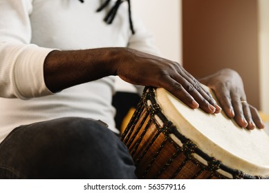 Musician Playing Drum with his hands.
