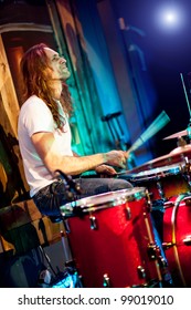 musician playing drums on a red background - Shutterstock ID 99019010