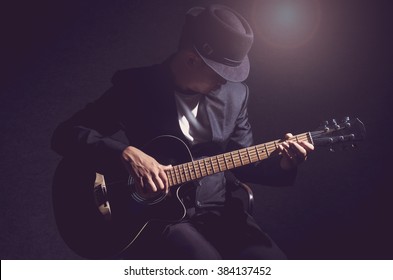 Musician playing the guitar on black background,music concept