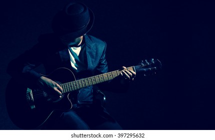 Musician playing the guitar on black background,music concept - Shutterstock ID 397295632