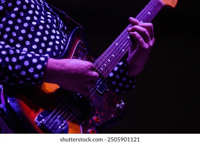 Musician playing guitar in polka dot shirt - Powered by Shutterstock