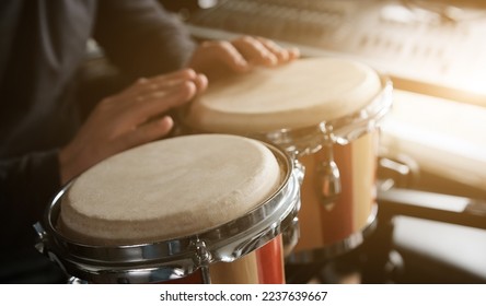 Musician playing hand Bongo Drums indoors closeup. Man with traditional ethnic folk music instrument - Shutterstock ID 2237639667