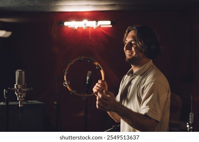 Musician playing a tambourine during a recording session - Powered by Shutterstock