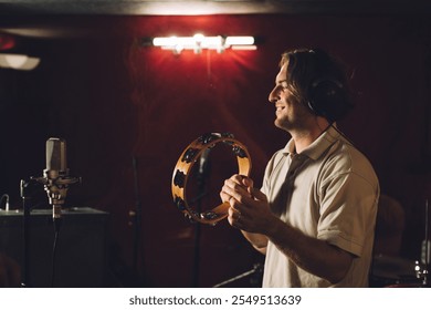 Musician playing a tambourine during a recording session - Powered by Shutterstock