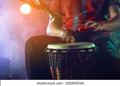 The musician plays the bongo on stage. Stage light. Smoke. - Powered by Shutterstock