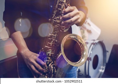 musician plays tenor saxophone on stage with blurred music instrument and Bokeh light  background
 - Shutterstock ID 1052902511