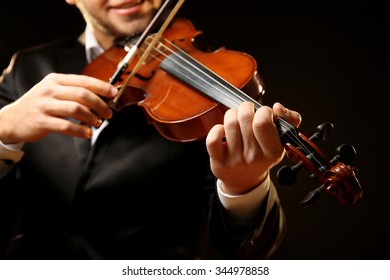 Musiker spielt Geige auf schwarzem Hintergrund, Nahaufnahme