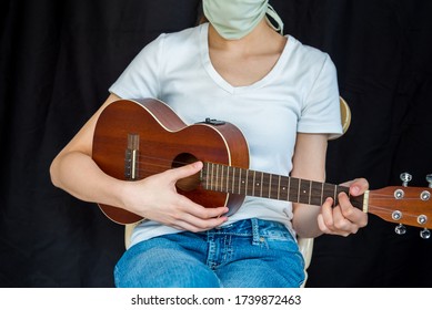 Musician Wearing Face Mask And Performing On Ukulele During Coronavirus COVID-19 Pandemic