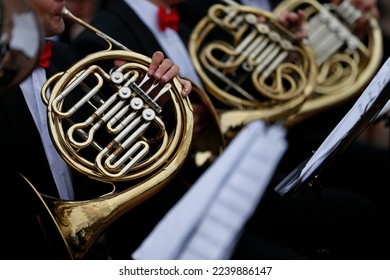 Musicians play the horn wind instrument.French horn instrument, hands playing horn player in philharmonic orchestra
