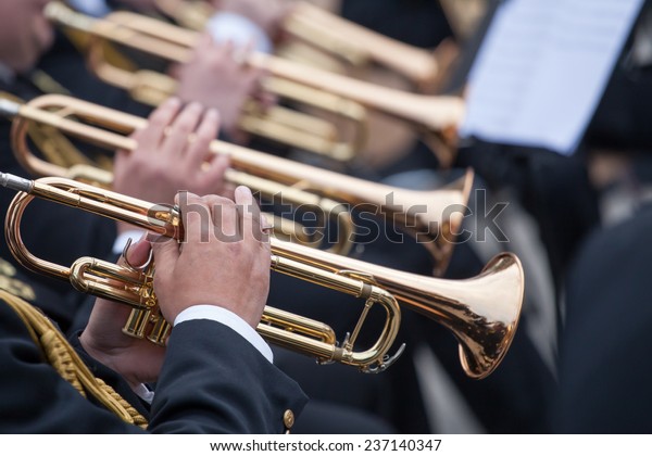 musicians are playing on\
trumpets 