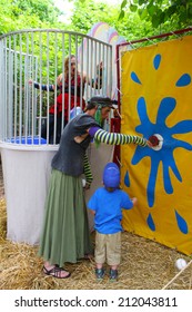 MUSKOGEE, OK - MAY 24: A Man Dressed As A Woman Calls People For A Game Of Dunk Tank At The Oklahoma 19th Annual Renaissance Festival On May 24, 2014 At The Castle Of Muskogee In Muskogee, OK 