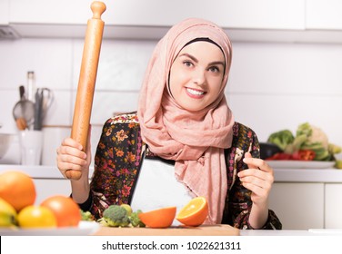 Muslim Arab Woman With Hijab Holding Rolling Pin Kitchen Prepering Some Vegan Meal.