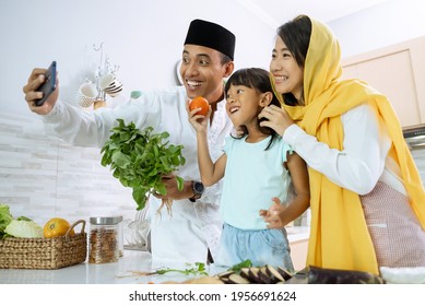 Muslim Asian Family Take Selfie During Iftar Dinner Preparation Together At Home