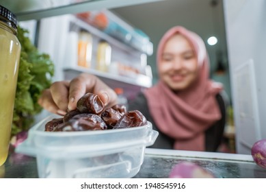 Muslim Asian Woman Eating Dates Fruit From The Fridge