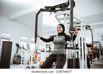 Muslim Asian Woman Using Chest Press Machine During Fitness At The Gym