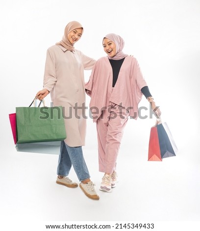 muslim bestfriend happy holding a shopping bag over white background