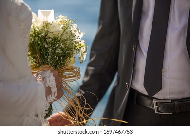 Muslim bride in  holds a wedding bouquet  , wedding details , in white wedding dress