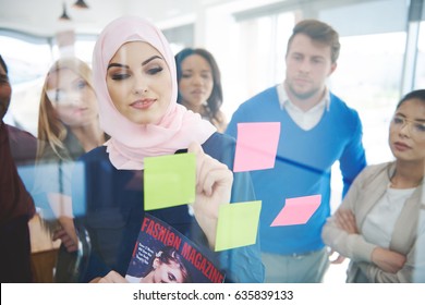 Muslim business woman manage the meeting. Covers magazine visible on the picture are out project and have proper PR.