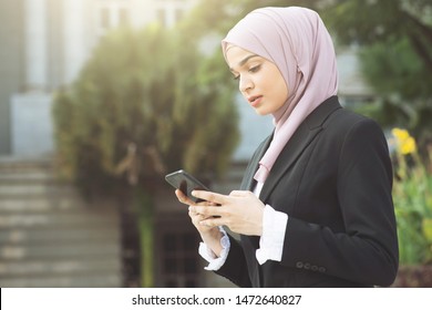 Muslim Business Woman Walking And Using Smart Phone.