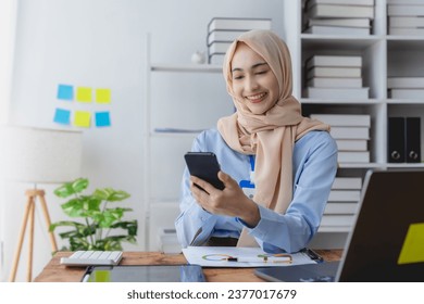 Muslim businesswoman using mobile phone in the office. - Powered by Shutterstock