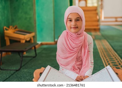Muslim child girl learning a holy book Quran in the mosque.	