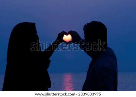 A Muslim couple finds love's tranquility on the beach, Sunset Serenade: Embracing Love's Glow. cherishes an enchanting Islamic-minded moment on the beach, bathed in the beauty of the setting sun,