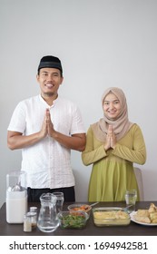 Muslim Couple Greeting While Standing In Front Of Their Table With Food On Hari Raya Eid Mubarak Kareem