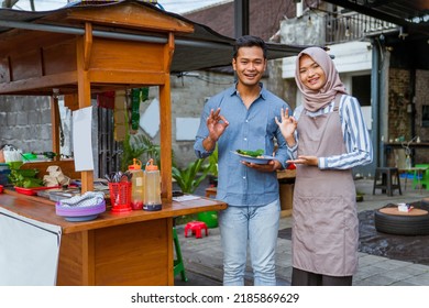 muslim couple ordering food to break fasting in traditional food market stall served by the seller - Shutterstock ID 2185869629