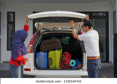 Muslim Couple Packing For Camping By Closing Rear Car Trunk