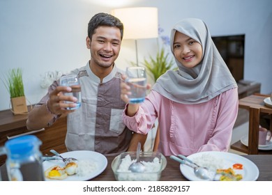 Muslim Couple Wake Up Early To Have Sahur Or Suhur Breakfast For Fasting. Clock At Foreground Showing The Time