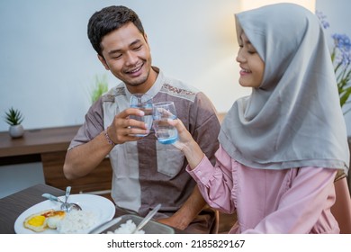 Muslim Couple Wake Up Early To Have Sahur Or Suhur Breakfast For Fasting. Clock At Foreground Showing The Time