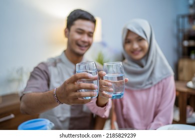 Muslim Couple Wake Up Early To Have Sahur Or Suhur Breakfast For Fasting. Clock At Foreground Showing The Time