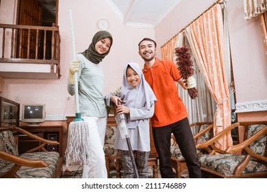 Muslim Family Happiness Holding Cleaning Tools While Cleaning The Room