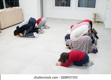 Muslim Family Praying Together At Home