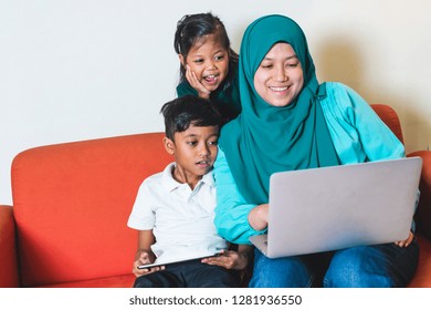 Muslim Family - Single Mum And Children - Watching Movie On A Laptop. Indoor, At Home. Cheerful Expression