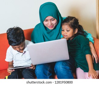 Muslim Family - Single Mum And Children - Watching Movie On A Laptop. Indoor, At Home.