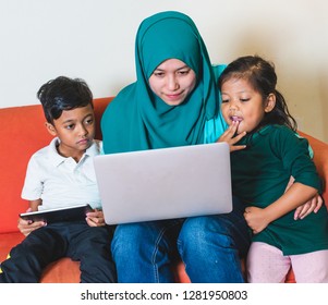 Muslim Family - Single Mum And Children - Watching Movie On A Laptop. Indoor, At Home.