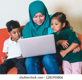 Muslim Family - Single Mum And Children - Watching Movie On A Laptop. Indoor, At Home.