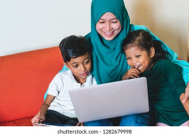 Muslim Family - Single Mum And Children - Happily Watching Movie On A Laptop. Indoor, At Home.