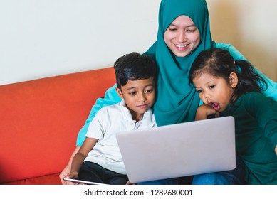 Muslim Family - Single Mum And Children - Happily Watching Movie On A Laptop. Indoor, At Home.