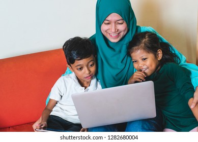 Muslim Family - Single Mum And Children - Happily Watching Movie On A Laptop. Indoor, At Home.