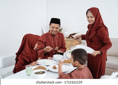 Muslim Family Sit To Eat When Breaking Fast Together At Home