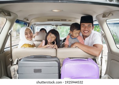 Muslim Family Travel By Car During Eid Mubarak Celebration. Asian People Going Back To Their Hometown