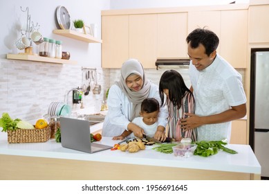 Muslim Family With Two Children Cooking Together At Home Preparing For Dinner And Iftar Break Fasting