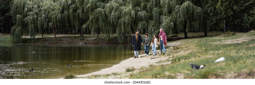 Muslim Family Walking Near Lake In Park, Banner