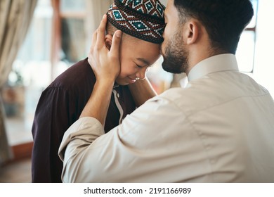 Muslim father, parent or man kissing his son on the forehead, bonding and showing affection at home. Happy, smiling and Arab boy embracing, celebrating traditional holiday and being peaceful 