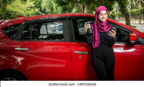 Muslim Female with her smartphone beside her car. Car insurance concept. - Powered by Shutterstock